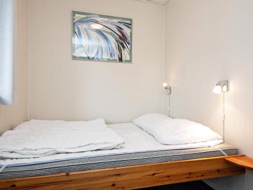 a bed in a room with a picture on the wall at 6 person holiday home in B rkop in Børkop