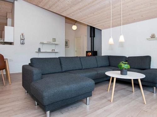 sala de estar con sofá azul y mesa en 8 person holiday home in Glesborg en Glesborg