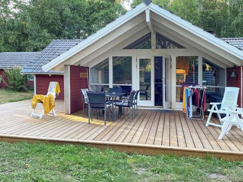 una terraza de madera con mesa y sillas. en 4 person holiday home in Martofte, en Martofte