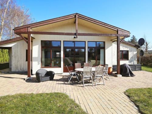 Cette maison dispose d'une terrasse avec une table et des chaises. dans l'établissement 6 person holiday home in Kirke Hyllinge, à Kirke-Hyllinge