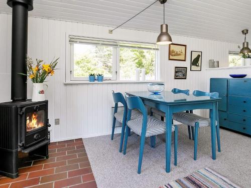 Vester Vidstrupにある5 person holiday home in Hj rringのコンロ付きの客室で、青いテーブルと椅子が備わります。