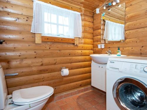 a log cabin bathroom with a washer and dryer at Holiday home Knebel V in Knebel