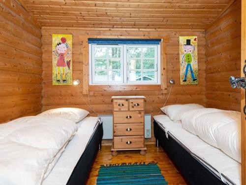 a bedroom with two beds in a log cabin at Seaside Serenity at SkAdshoved-By Traum in Knebel