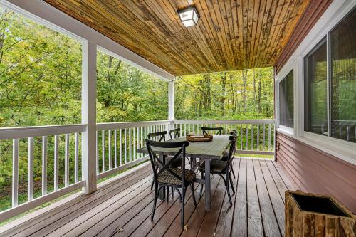 a screened porch with a table and chairs on it at Rocky Red in Bromley Village