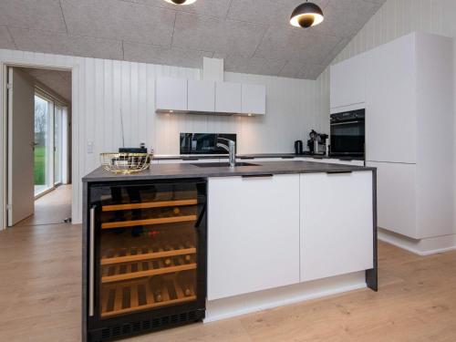 a kitchen with a counter with a wine cellar at 8 person holiday home in Sydals in Mommark
