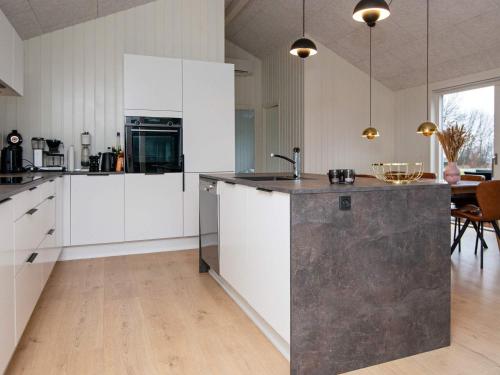 a kitchen with white cabinets and a black counter top at 8 person holiday home in Sydals in Mommark