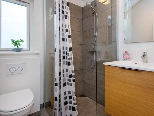 ein Bad mit einer Dusche, einem WC und einem Waschbecken in der Unterkunft Holiday home Sydals XLI in Mommark