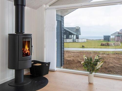 a fireplace in a living room next to a window at 8 person holiday home in Sydals in Mommark