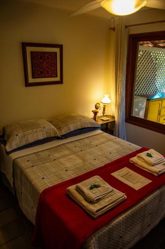 a bedroom with a bed with towels on it at Aconchego Itaipava in Petrópolis