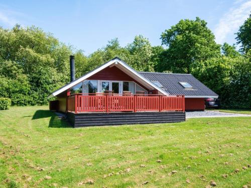 a small red house with a red deck on a field at 6 person holiday home in Toftlund in Toftlund