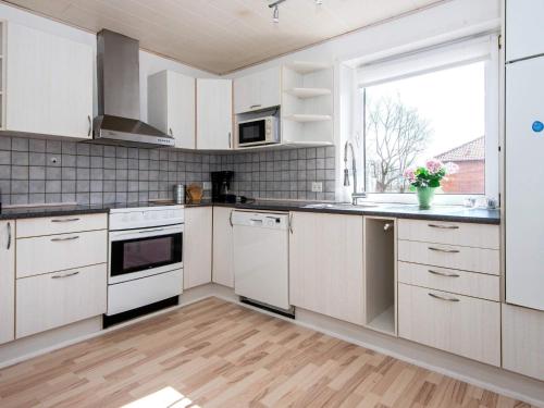 een keuken met witte kasten en een raam bij 4 person holiday home in Toftlund in Toftlund
