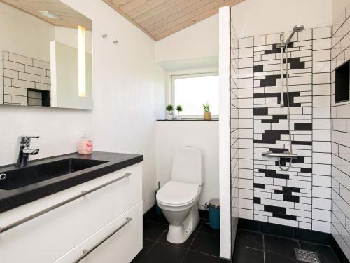a white bathroom with a sink and a toilet at Holiday home Oksbøl LXIX in Oksbøl