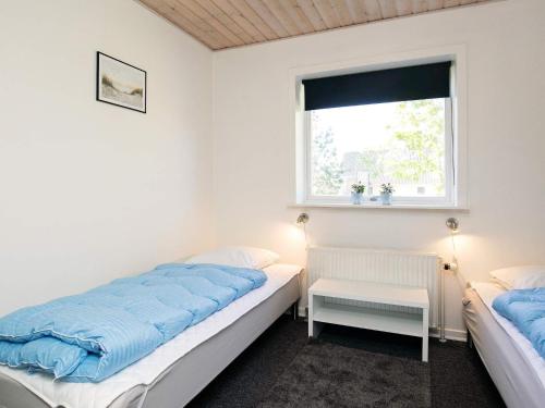 a bedroom with two beds and a window at Holiday home Oksbøl LXIX in Oksbøl