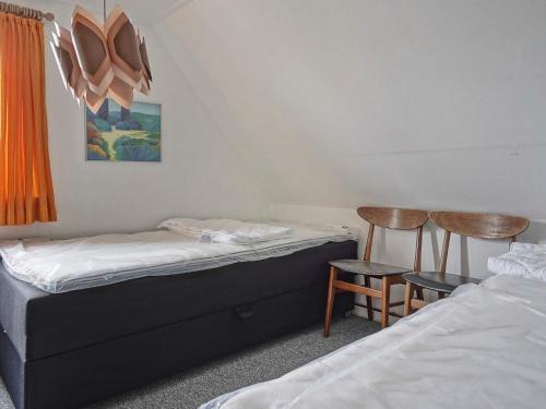 two beds in a room with two tables and two chairs at 8 person holiday home in Hasle in Hasle