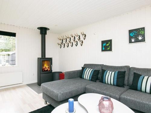 a living room with a couch and a fireplace at 5 person holiday home in H jslev in Højslev