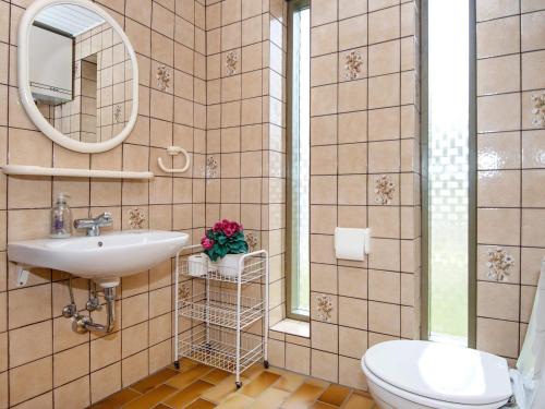 a bathroom with a sink and a toilet and a mirror at Holiday home Glesborg XIX in Glesborg