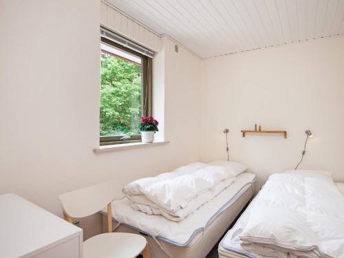 two beds in a white room with a window at Holiday home Glesborg XIX in Glesborg