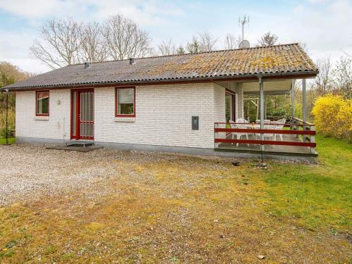 a small white house with a red door at 6 person holiday home in Glesborg in Glesborg