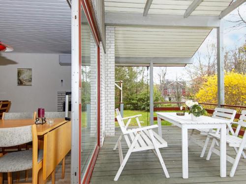a patio with a white table and chairs on a deck at 6 person holiday home in Glesborg in Glesborg