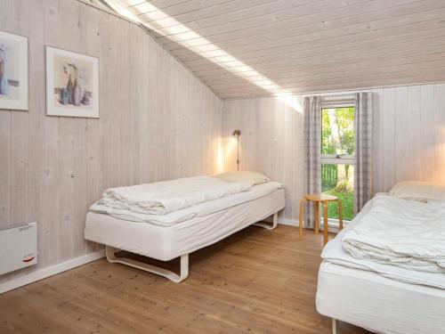 a bedroom with two beds and a window at Four-Bedroom Holiday home in Glesborg 2 in Glesborg