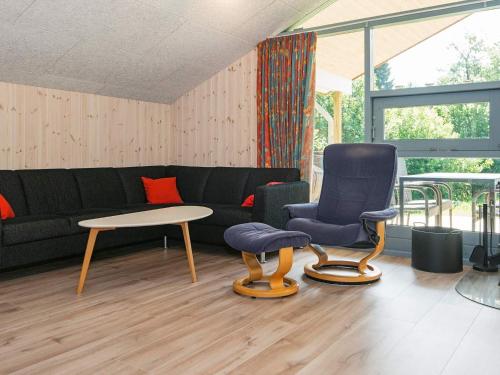 uma sala de estar com um sofá, uma mesa e cadeiras em 6 person holiday home in B rkop em Egeskov