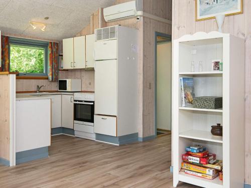 a kitchen with white cabinets and a refrigerator at 6 person holiday home in B rkop in Egeskov