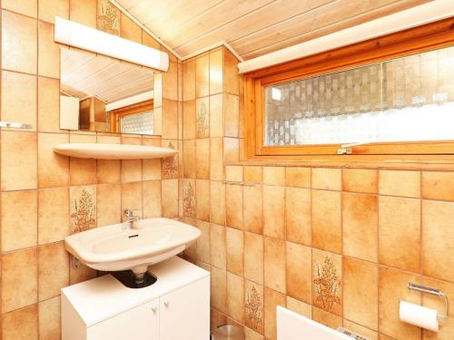 uma casa de banho com um lavatório e um espelho em Three-Bedroom Holiday home in Ringkøbing 1 em Ringkøbing