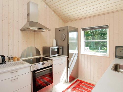 a kitchen with a refrigerator and a microwave at 5 person holiday home in V ggerl se in Marielyst