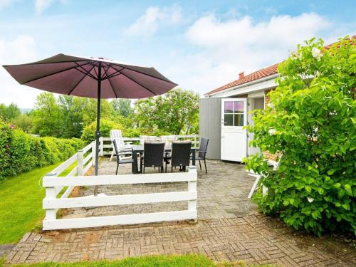 un patio con sombrilla, mesa y sillas en 6 person holiday home in Broager, en Broager