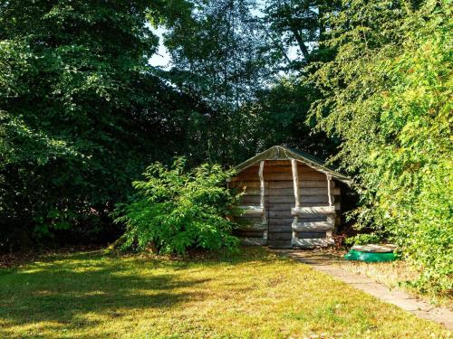 a small wooden cabin in the middle of a yard at 6 person holiday home in Ansager-By Traum in Ansager