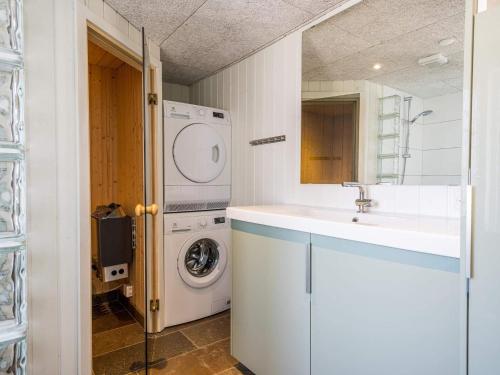ein Badezimmer mit einem Waschbecken und einer Waschmaschine in der Unterkunft Holiday home Henne CXVIII in Henne Strand