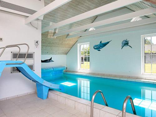 a pool with a slide in a swimming pool at 12 person holiday home in V ggerl se in Marielyst