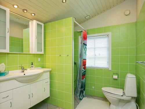 ein grünes Bad mit einem WC und einem Waschbecken in der Unterkunft Holiday home Brenderup Fyn IX in Bro