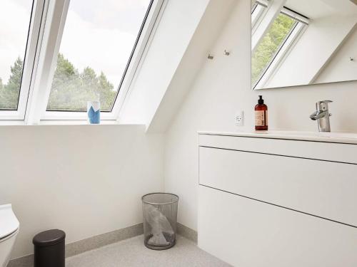 Baño blanco con ventanas y lavabo en Holiday home Hurup Thy XIII, en Sønder Ydby