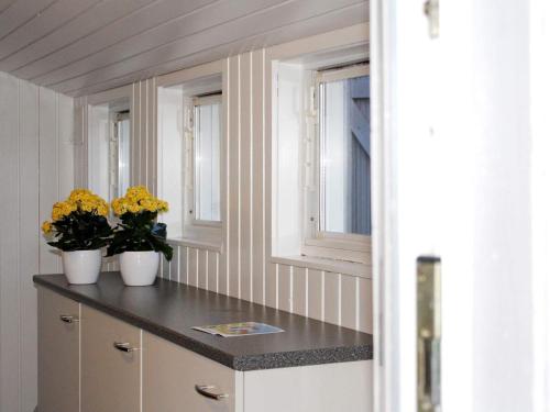 uma cozinha com dois vasos com flores amarelas num balcão em Holiday home Esbjerg V XVII em Esbjerg