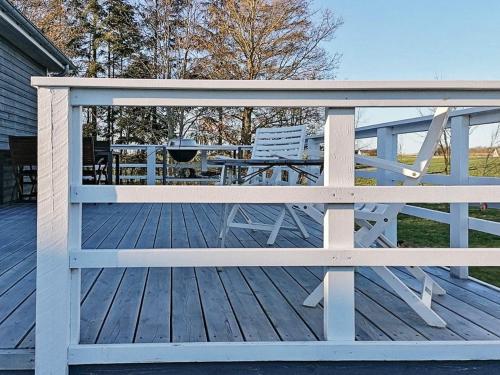 une terrasse en bois avec un banc et une table dans l'établissement 5 person holiday home in Vordingborg, à Vordingborg