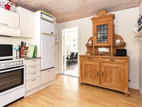 una cocina con electrodomésticos blancos y armarios de madera en 6 person holiday home in S by r, en Søby
