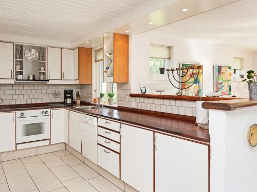 a kitchen with white cabinets and white appliances at 8 person holiday home in Glesborg in Glesborg