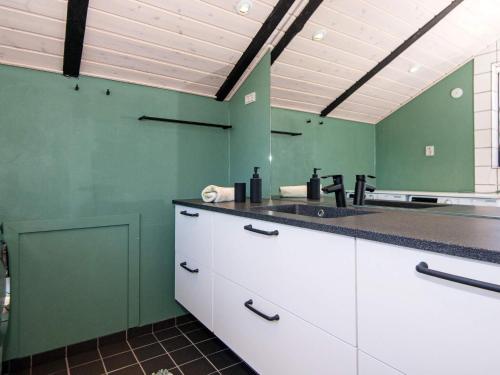 een keuken met groene muren en een aanrecht met een wastafel bij Holiday home Ringkøbing LXI in Ringkøbing