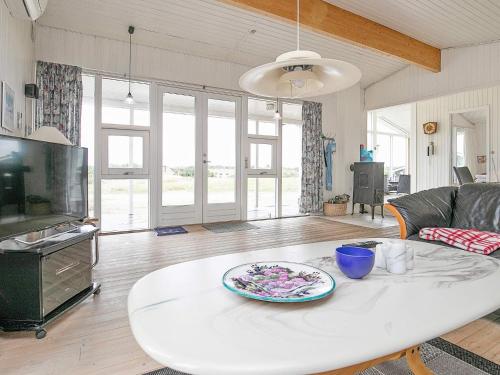 バイアス・スタンにある5 person holiday home in Vejers Strandのリビングルーム(白いテーブル、皿付)