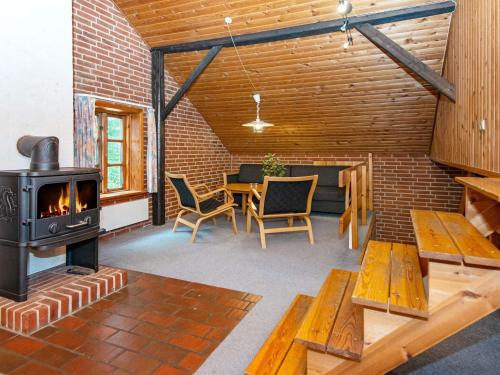 a living room with a fireplace and a table and chairs at 16 person holiday home in Skjern-By Traum in Skjern
