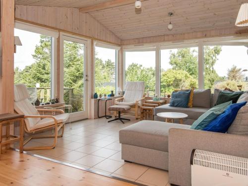 a screened in porch with a couch and chairs at 7 person holiday home in Knebel in Knebel