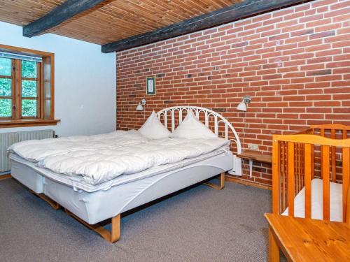 uma cama num quarto com uma parede de tijolos em Holiday home Skjern XVII em Skjern