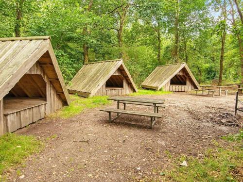 a group of three huts with a picnic table and benches at 16 person holiday home in Skjern-By Traum in Skjern