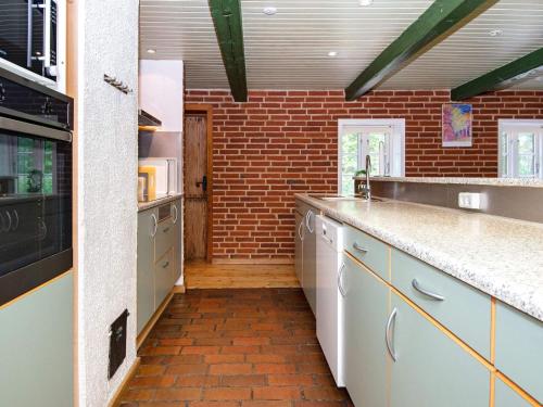 a large kitchen with a brick wall at 16 person holiday home in Skjern-By Traum in Skjern