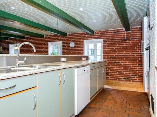 uma cozinha com um lavatório e uma parede de tijolos em Holiday home Skjern XVII em Skjern