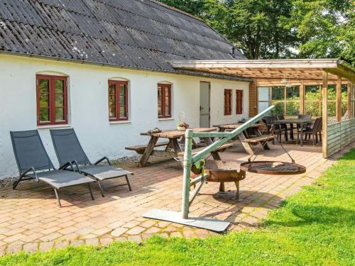 a patio with a picnic table and chairs and a house at 16 person holiday home in Skjern-By Traum in Skjern