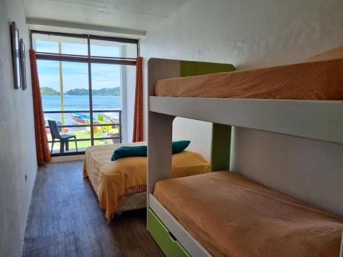 a bedroom with two bunk beds and a view of the ocean at Casa Bajo Congo in Colón