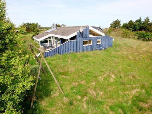 Bindslevにある9 person holiday home in Bindslevの草原の丘の上の青い家