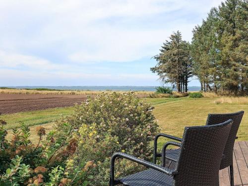 two chairs sitting on a deck looking out at a field at 8 person holiday home in Spøttrup in Spottrup